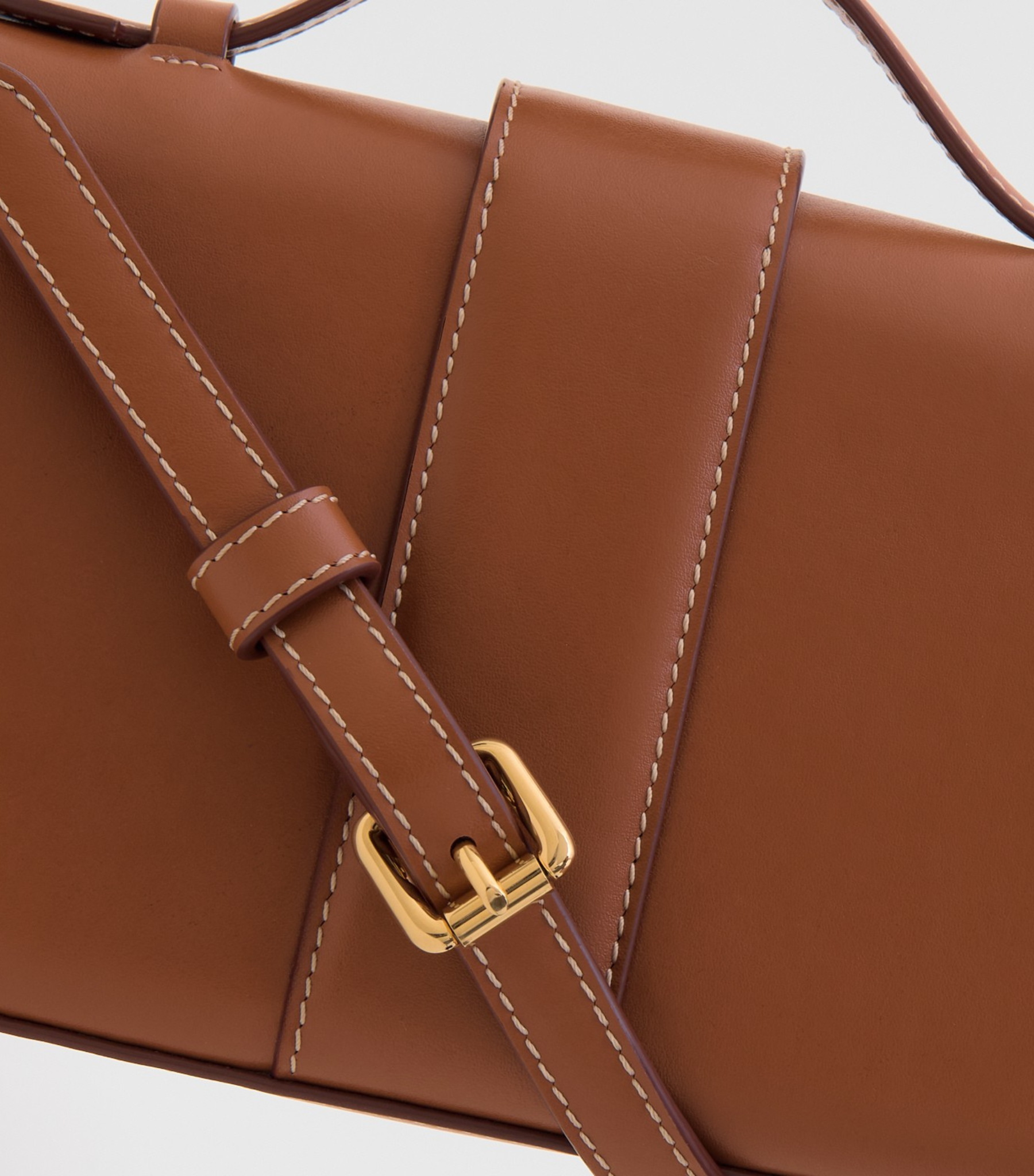Plant Based Vegan Luxury Sustainable Handbag Made in Spain Ubrique Ethical plant-based leather vegan leather savette symmetry pochette clutch top handle cognac tan brown contrast stitching brown small bag chic classy vegan luxury bags ethical luxury quiet luxury plastic-free leather best british handbag brands mid range handbags  stainless steel hardware gold plated handbag 18k 24k gold buckle hermes kelly pochette