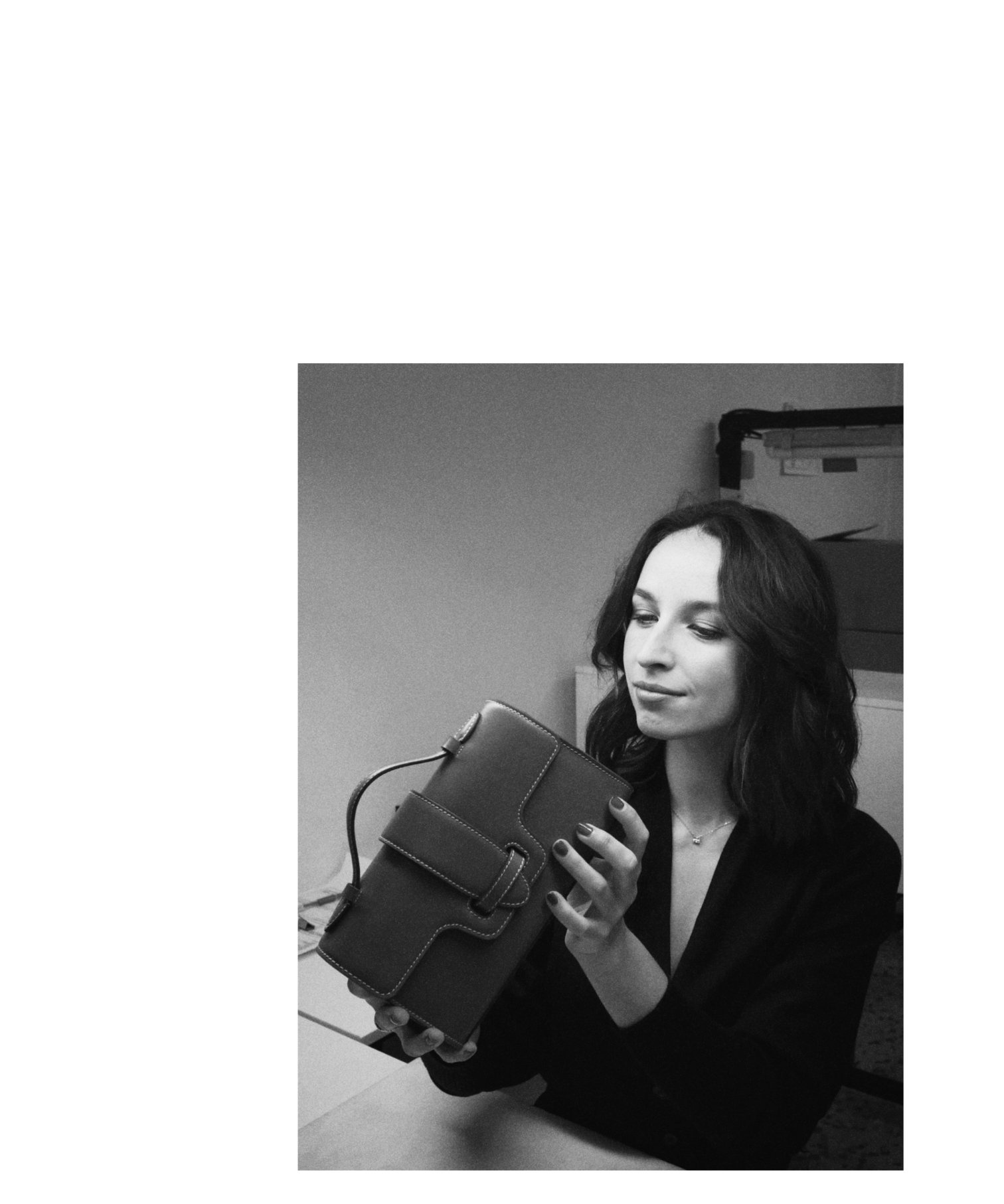Black and white photo of a woman holding a handbag.